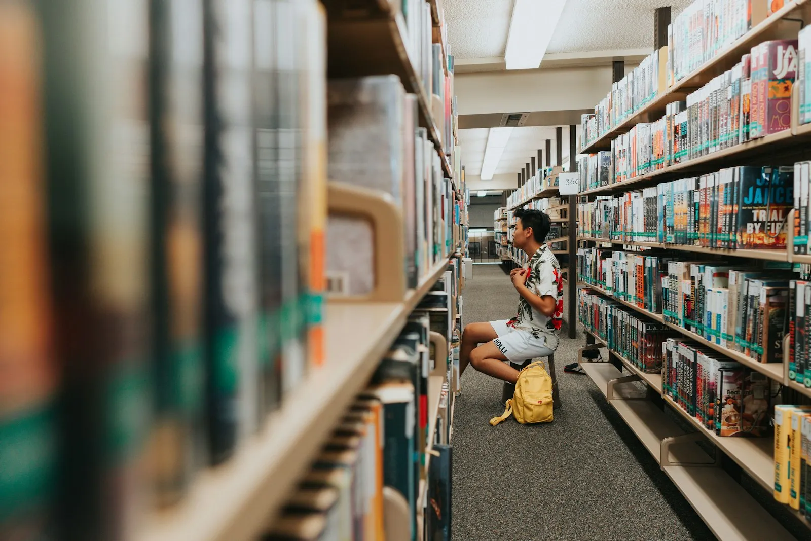 A person sitting on the floor in a library