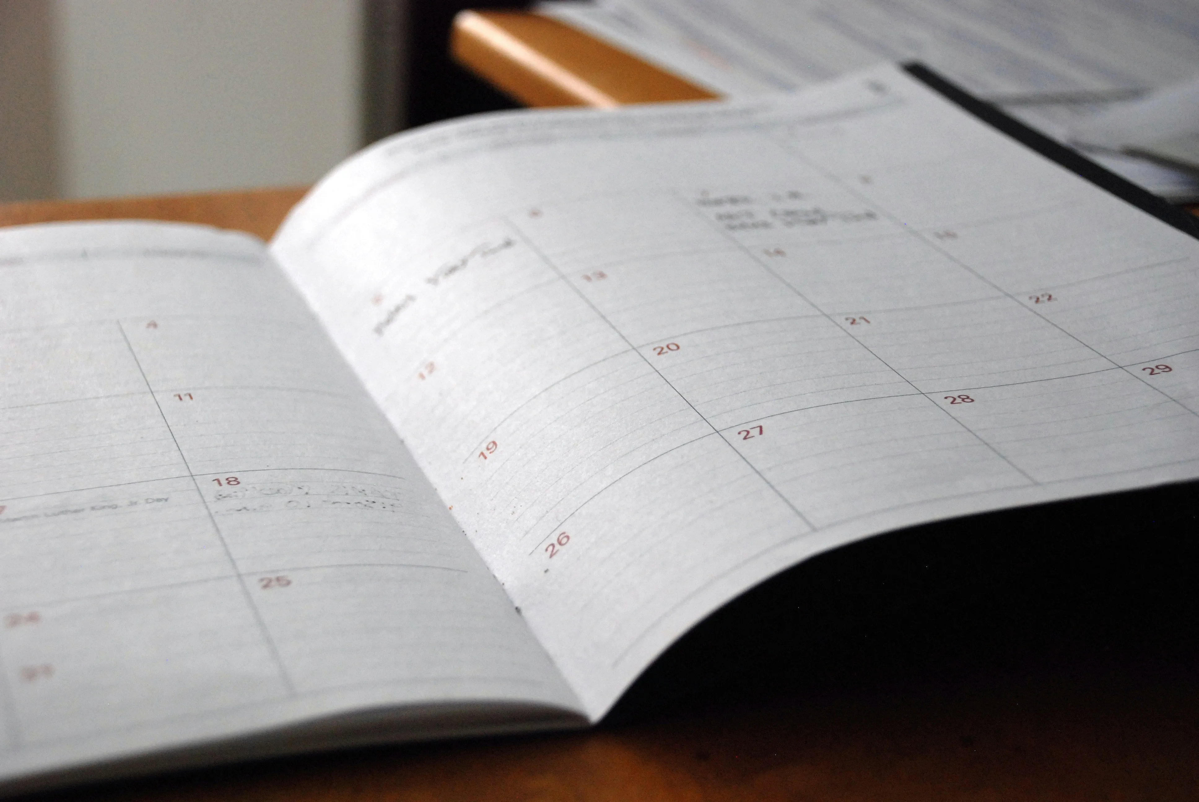 open monthly planner on wooden desk
