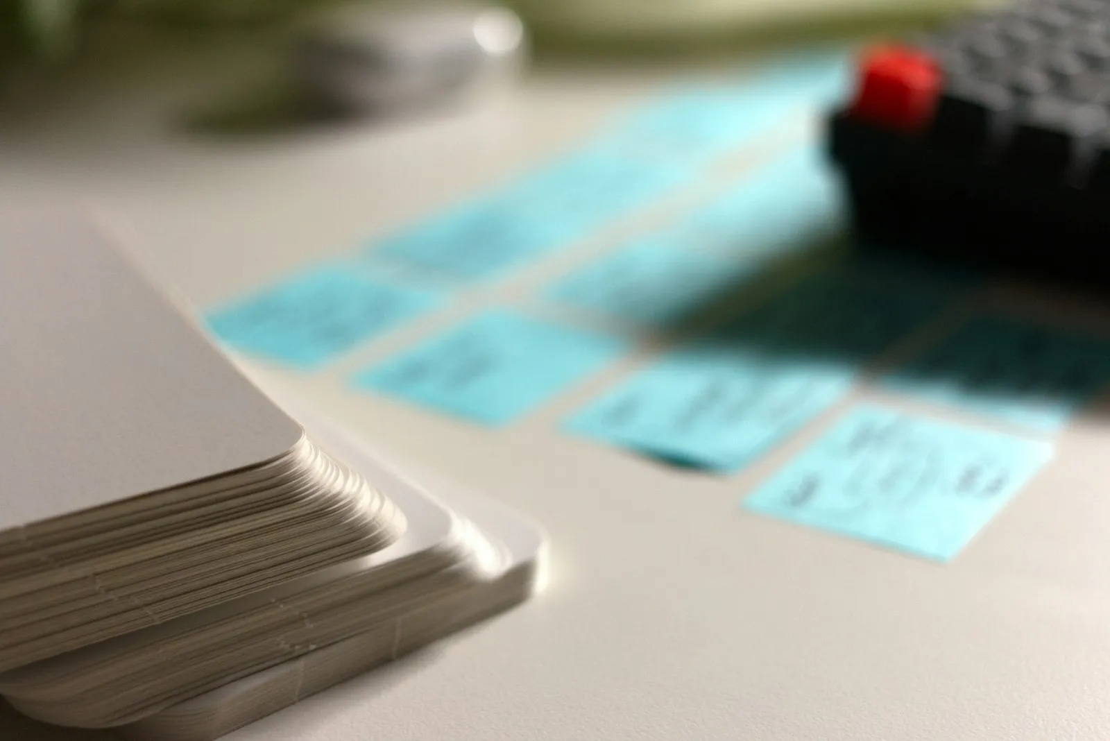 stack of blank index cards next to handwritten sticky notes on a desk